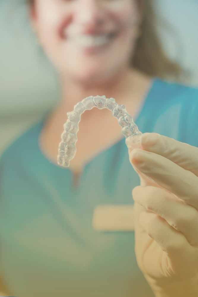 Clear aligners placed neatly alongside a cleaning brush and storage case, highlighting proper maintenance tools.